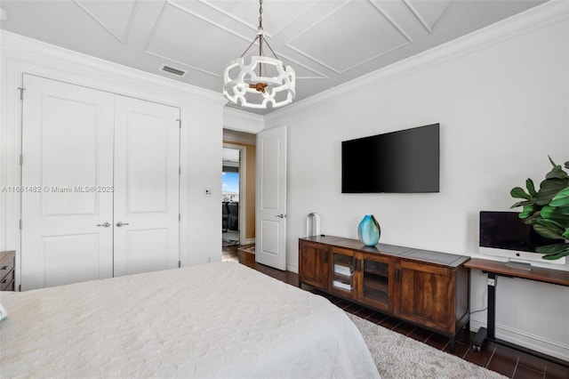 bedroom with ornamental molding, coffered ceiling, an inviting chandelier, and a closet