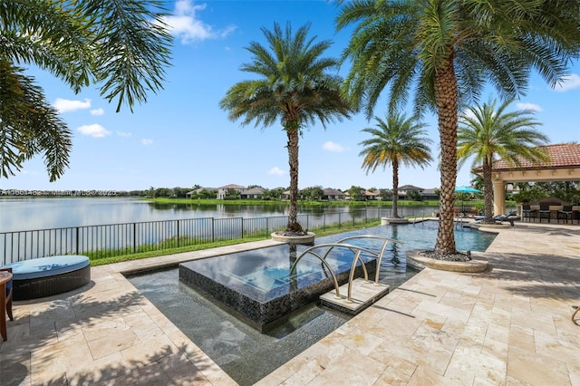 view of swimming pool with a water view and a patio area