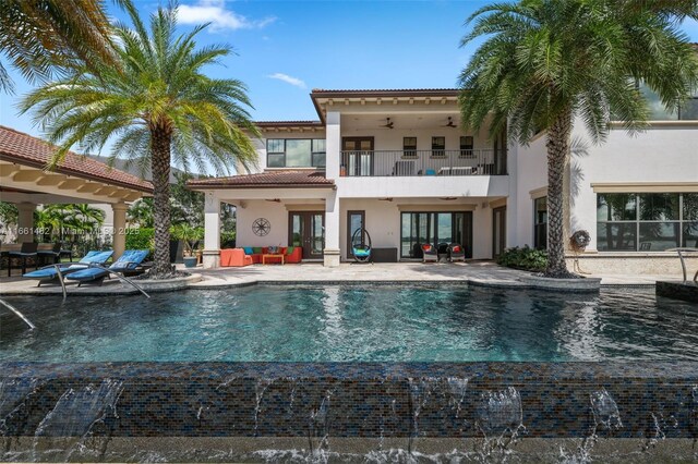 view of swimming pool with pool water feature, a water view, and a patio area