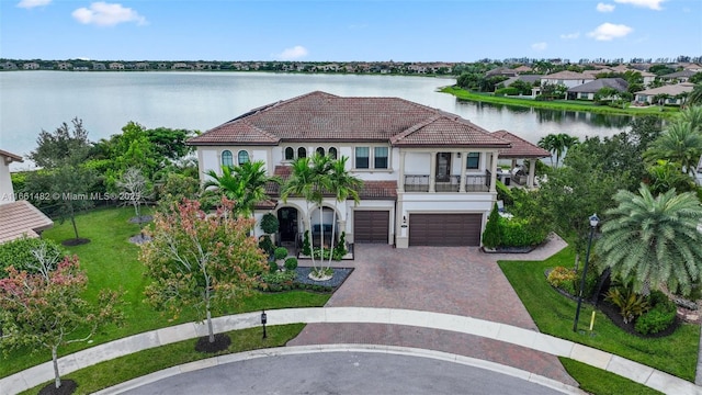 mediterranean / spanish-style home featuring a water view, a balcony, and a garage