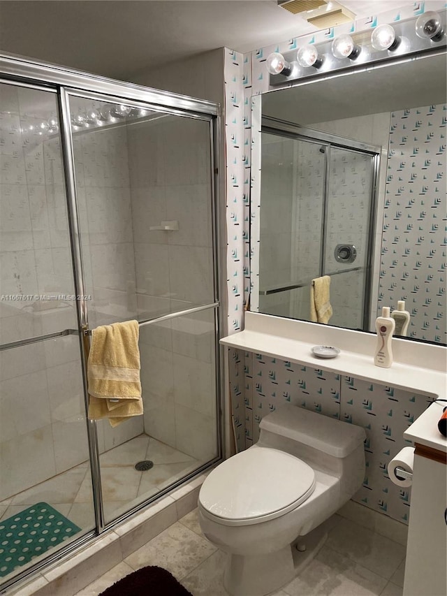 bathroom with tile patterned flooring, an enclosed shower, vanity, and toilet