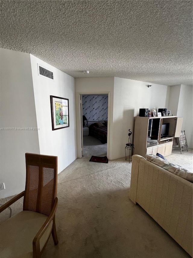 living room with a textured ceiling and light colored carpet