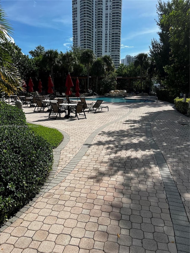 view of home's community with a pool and a patio area