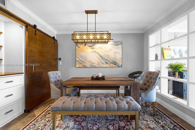 dining room with crown molding and a barn door