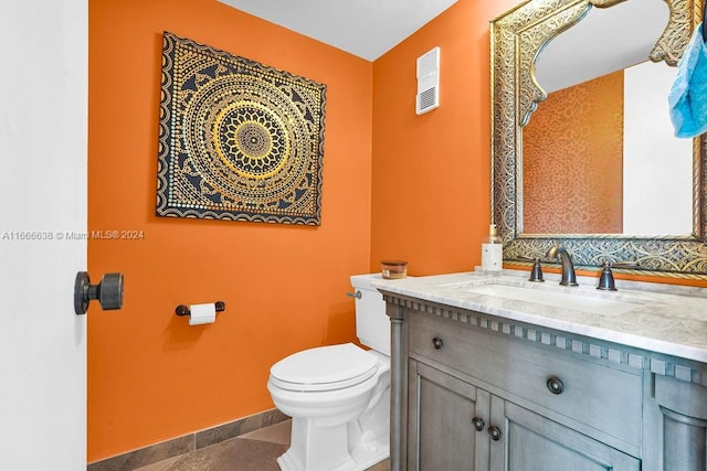 bathroom with tile patterned flooring, vanity, and toilet