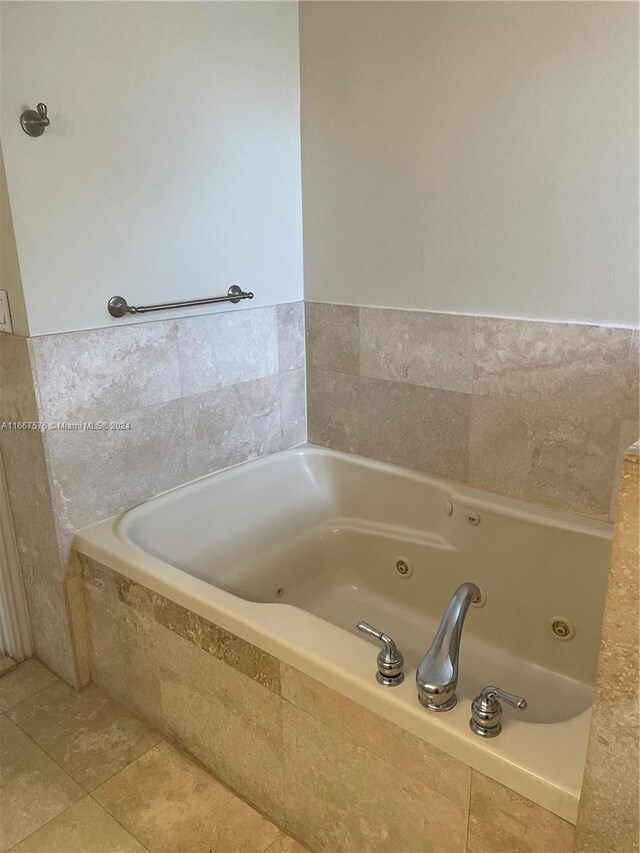 bathroom with tile patterned flooring and a relaxing tiled tub