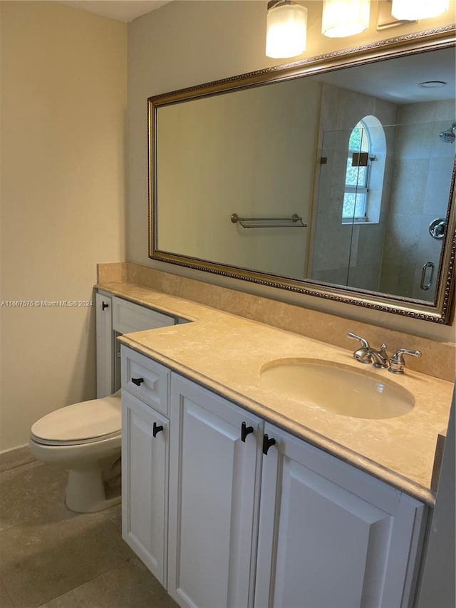 bathroom with vanity, toilet, and a shower with shower door