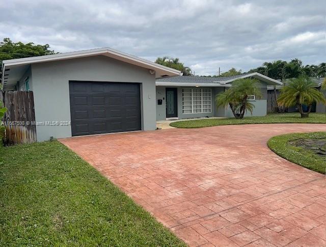 single story home with a garage and a front yard