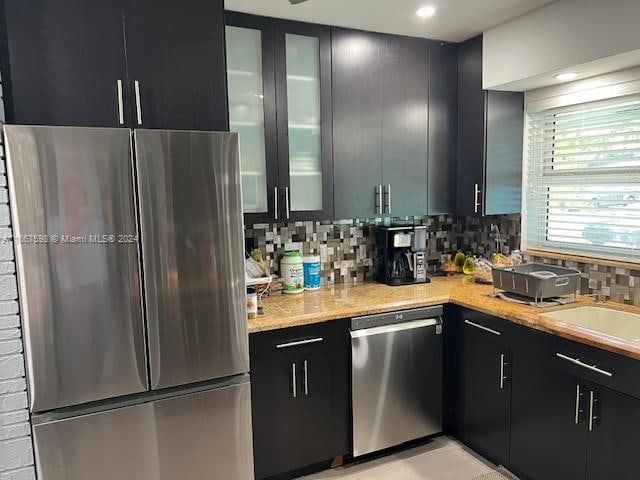 kitchen featuring decorative backsplash, appliances with stainless steel finishes, and sink