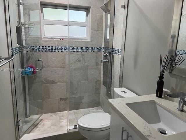 bathroom featuring toilet, vanity, and walk in shower