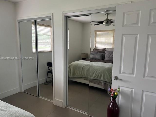 tiled bedroom featuring two closets and ceiling fan