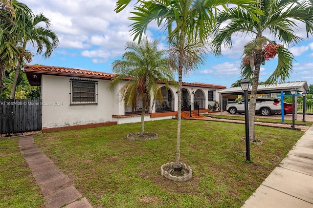 mediterranean / spanish home featuring a carport and a front yard