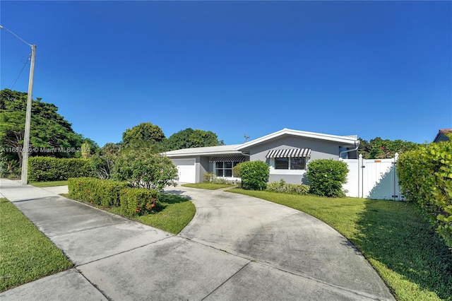 ranch-style home featuring a front lawn and a garage