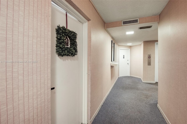 hallway with carpet floors and a textured ceiling