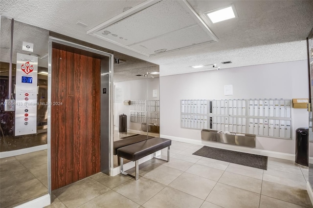 interior space with mail boxes, a textured ceiling, and tile patterned flooring