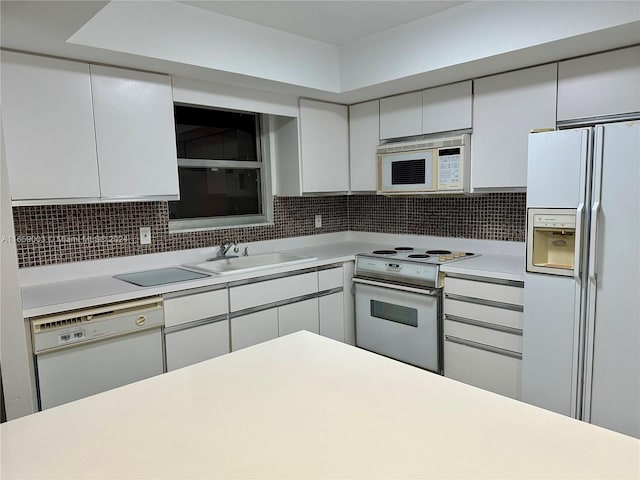 kitchen with white appliances, sink, tasteful backsplash, and white cabinets