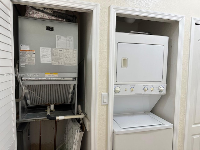 washroom featuring stacked washer / drying machine