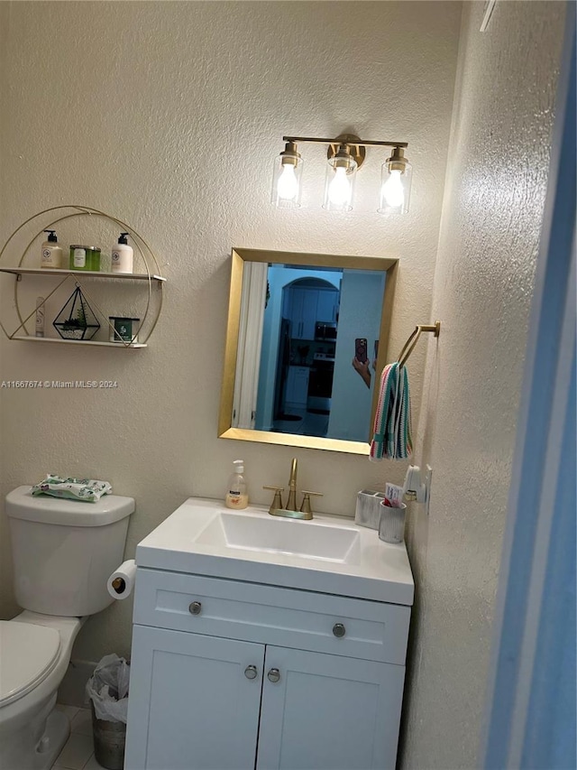 bathroom featuring tile patterned flooring, vanity, and toilet