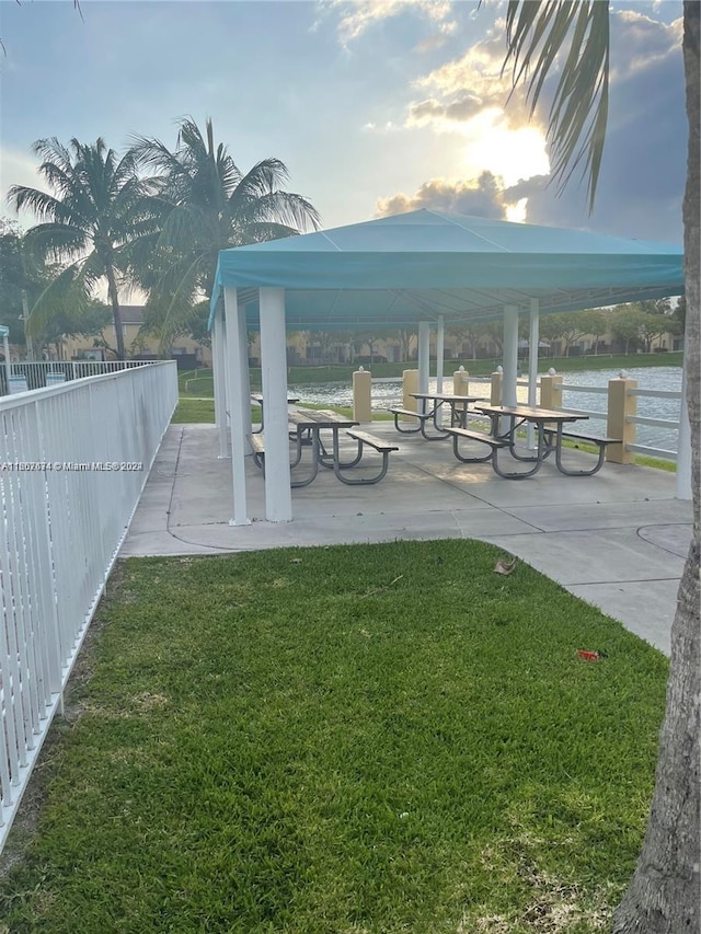 yard at dusk with a gazebo and a water view