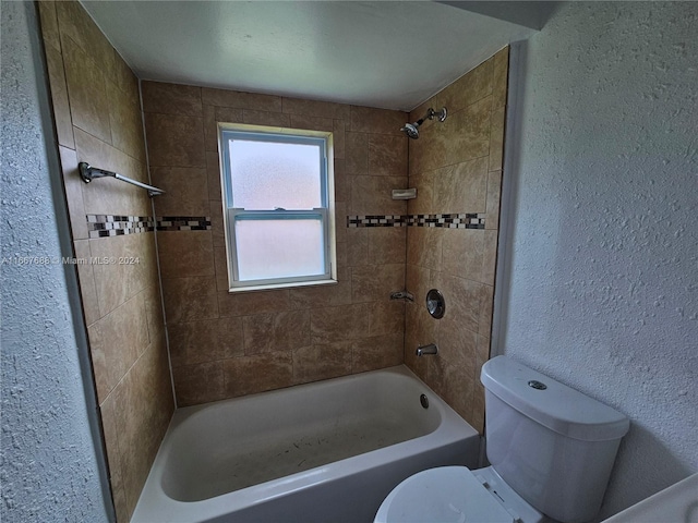 bathroom featuring tiled shower / bath and toilet