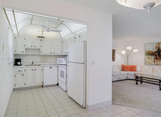 kitchen featuring sink, white appliances, ceiling fan, white cabinets, and light carpet