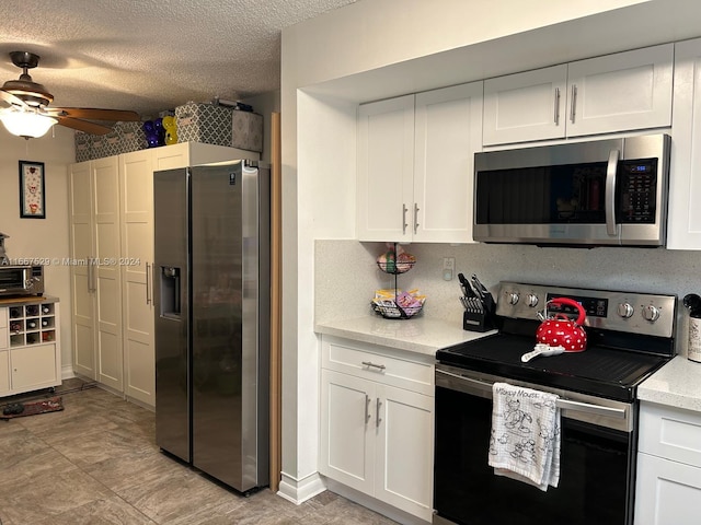 kitchen featuring ceiling fan, white cabinets, and stainless steel appliances