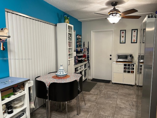 kitchen featuring a textured ceiling, white cabinetry, and ceiling fan