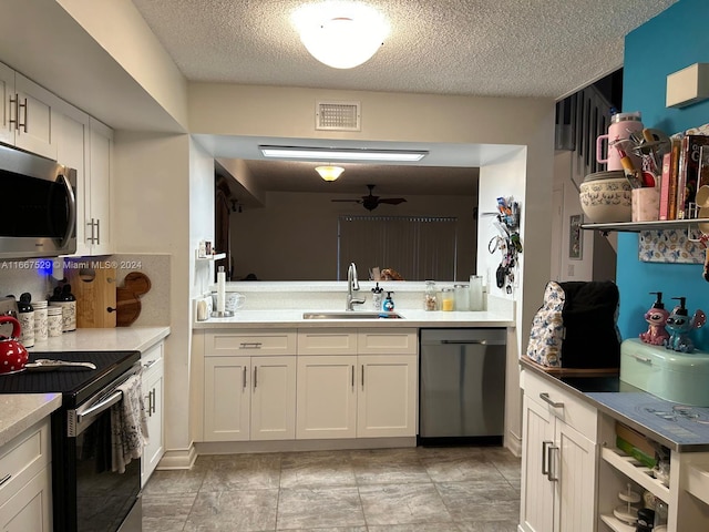 kitchen featuring a textured ceiling, sink, white cabinetry, appliances with stainless steel finishes, and ceiling fan