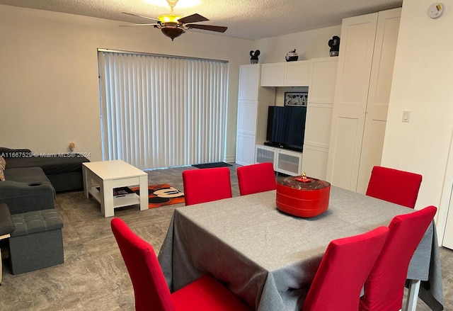 dining space featuring ceiling fan and a textured ceiling