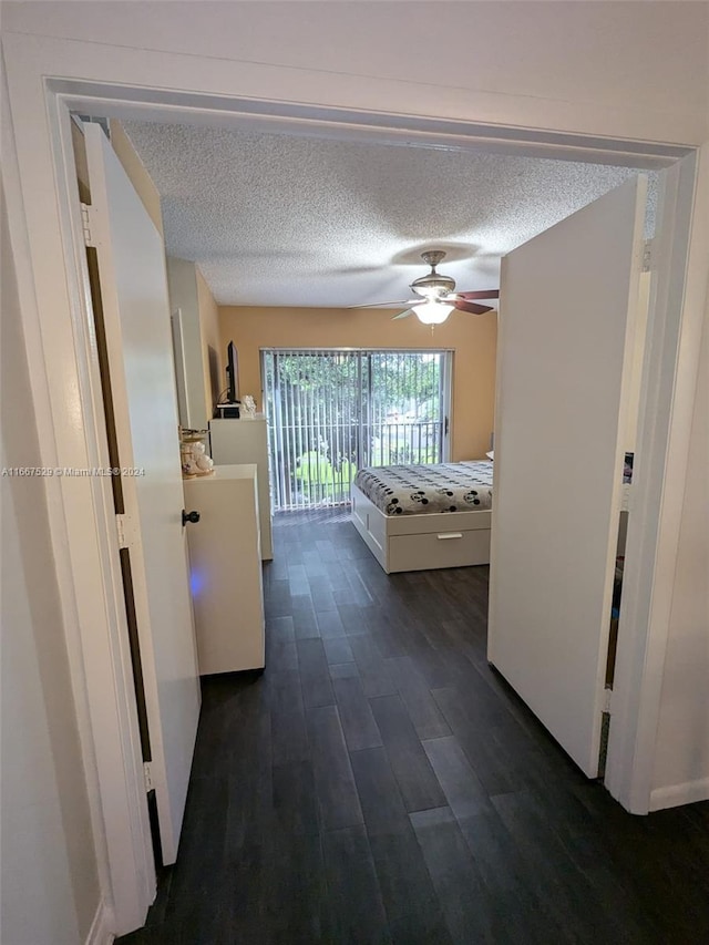 hall with a textured ceiling and dark hardwood / wood-style flooring