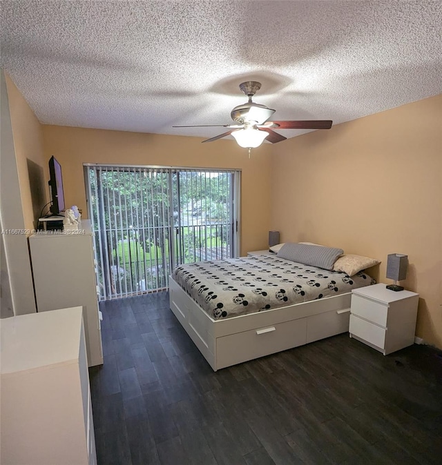 bedroom with ceiling fan, access to exterior, a textured ceiling, and dark hardwood / wood-style flooring