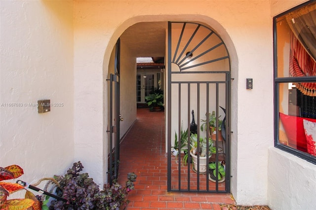 entrance to property with a gate and stucco siding