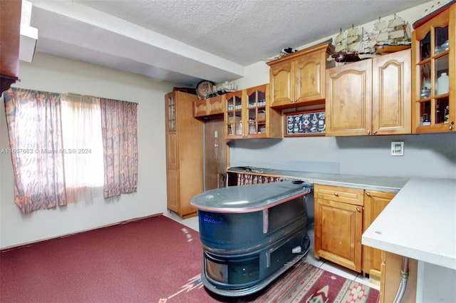 kitchen featuring dark carpet and a textured ceiling