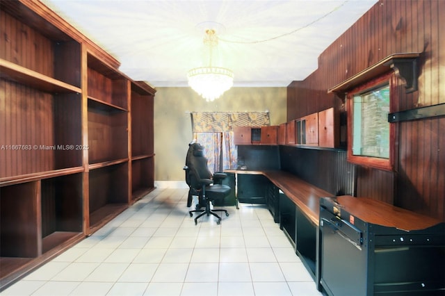 home office featuring wood walls, light tile patterned floors, a chandelier, and built in study area