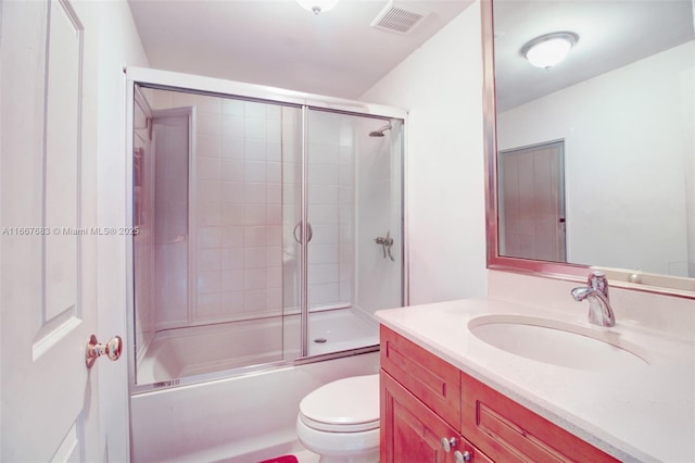 bathroom featuring visible vents, vanity, toilet, and bath / shower combo with glass door