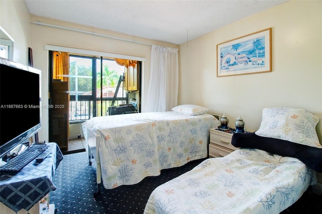 bedroom featuring access to outside, a textured ceiling, and carpet