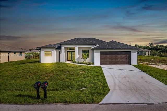 prairie-style house featuring a garage and a lawn