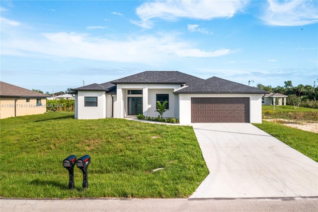 prairie-style house featuring a garage and a front lawn