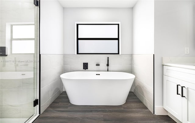 bathroom featuring tile walls, vanity, separate shower and tub, and hardwood / wood-style flooring