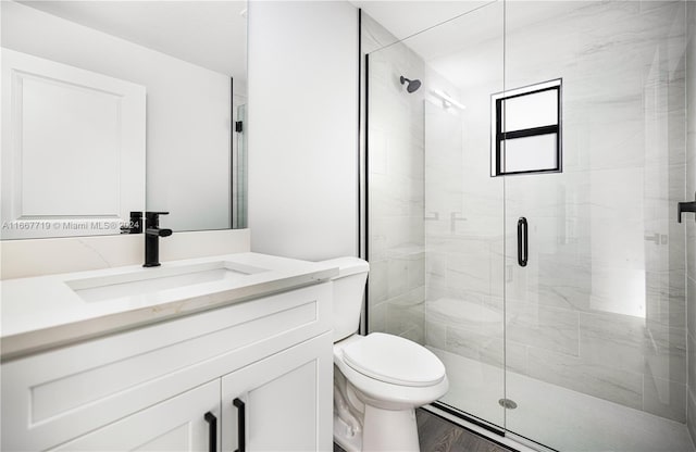 bathroom featuring vanity, wood-type flooring, toilet, and an enclosed shower