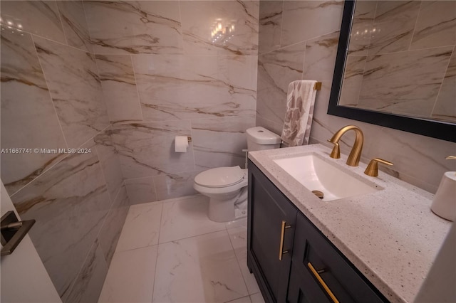 bathroom with tile walls, vanity, and toilet