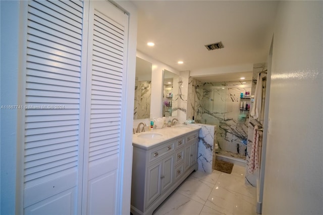 bathroom featuring a shower with shower door and vanity