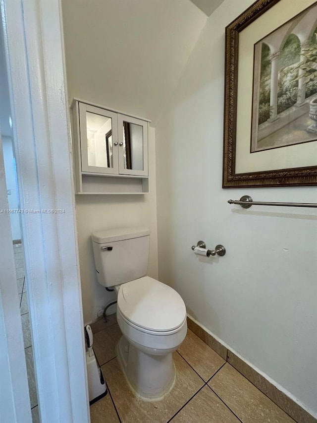 bathroom featuring vaulted ceiling, toilet, and tile patterned flooring