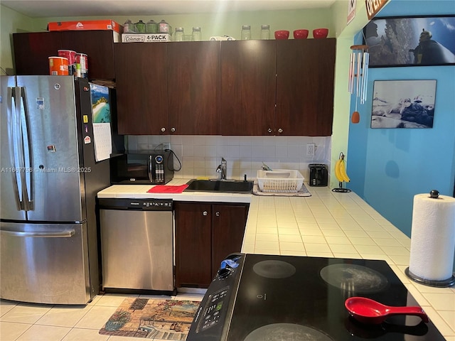 kitchen featuring sink, appliances with stainless steel finishes, dark brown cabinets, decorative backsplash, and tile countertops