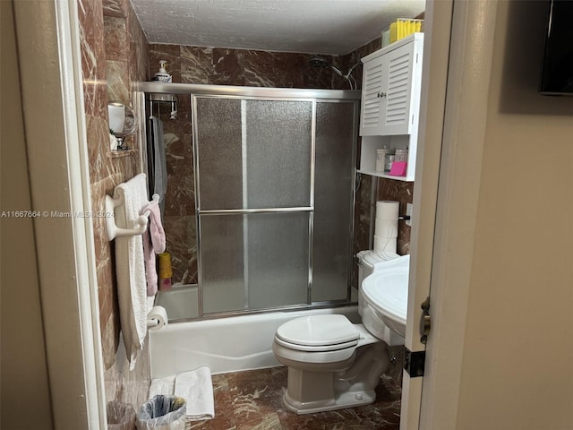 bathroom featuring shower / bath combination with glass door and toilet