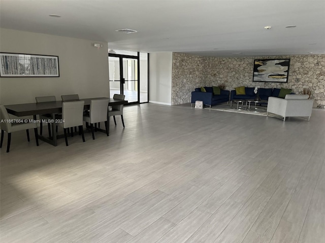 dining area with a large fireplace and light hardwood / wood-style floors