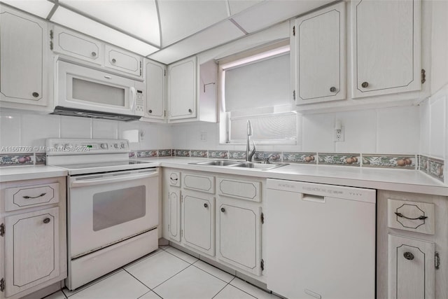 kitchen featuring white cabinetry, white appliances, light tile patterned floors, a paneled ceiling, and sink