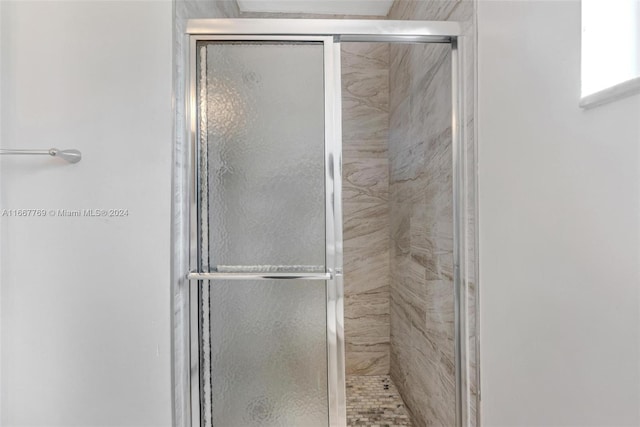 bathroom featuring a shower with door