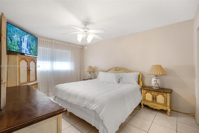 bedroom featuring ceiling fan, a textured ceiling, and light tile patterned floors