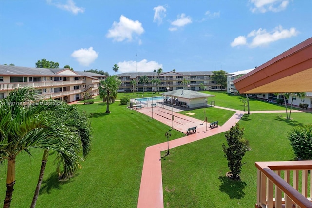 view of home's community featuring a swimming pool and a lawn